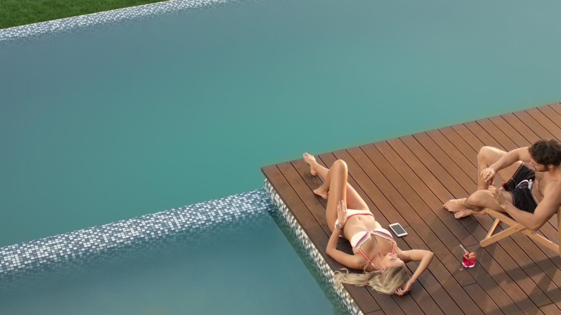 和男朋友在泳池边阳光浴模特视频的预览图