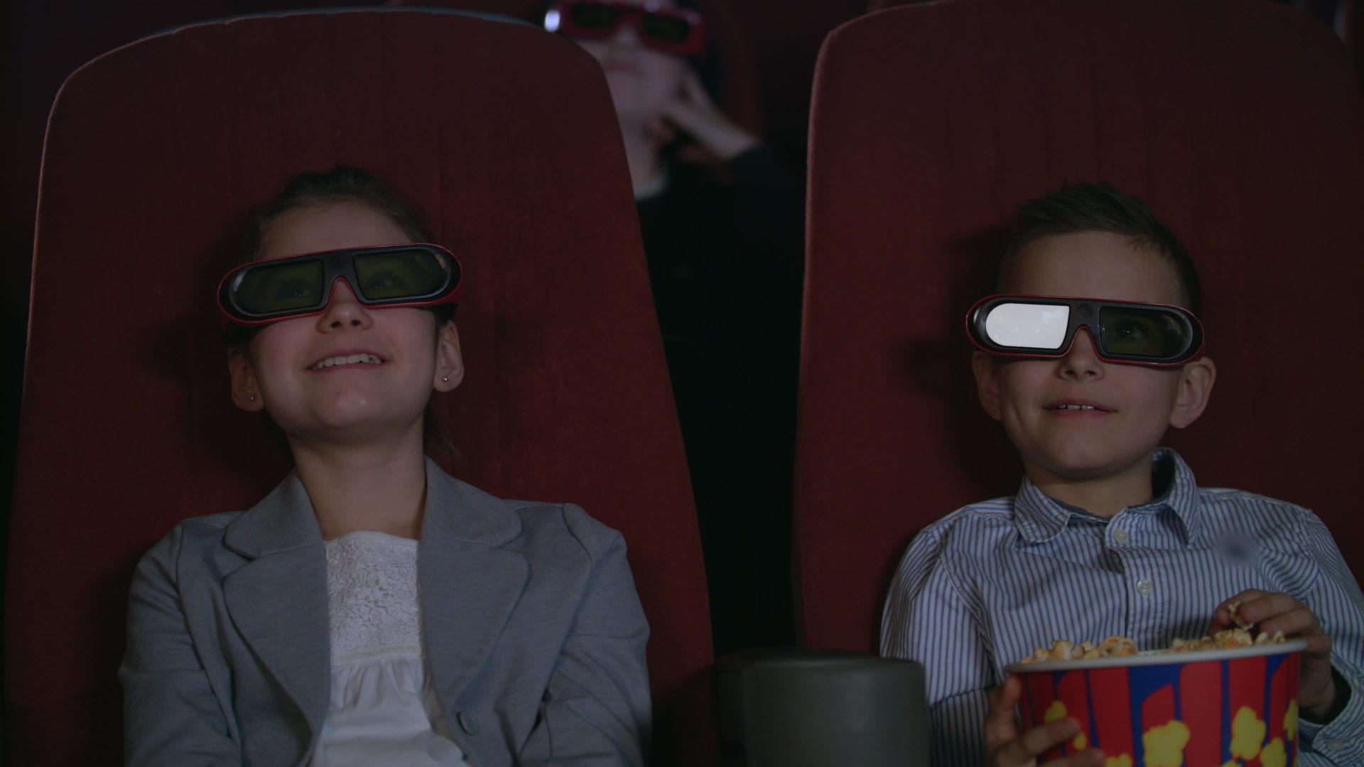 穿着3D漂亮的孩子对看电影感兴趣视频的预览图