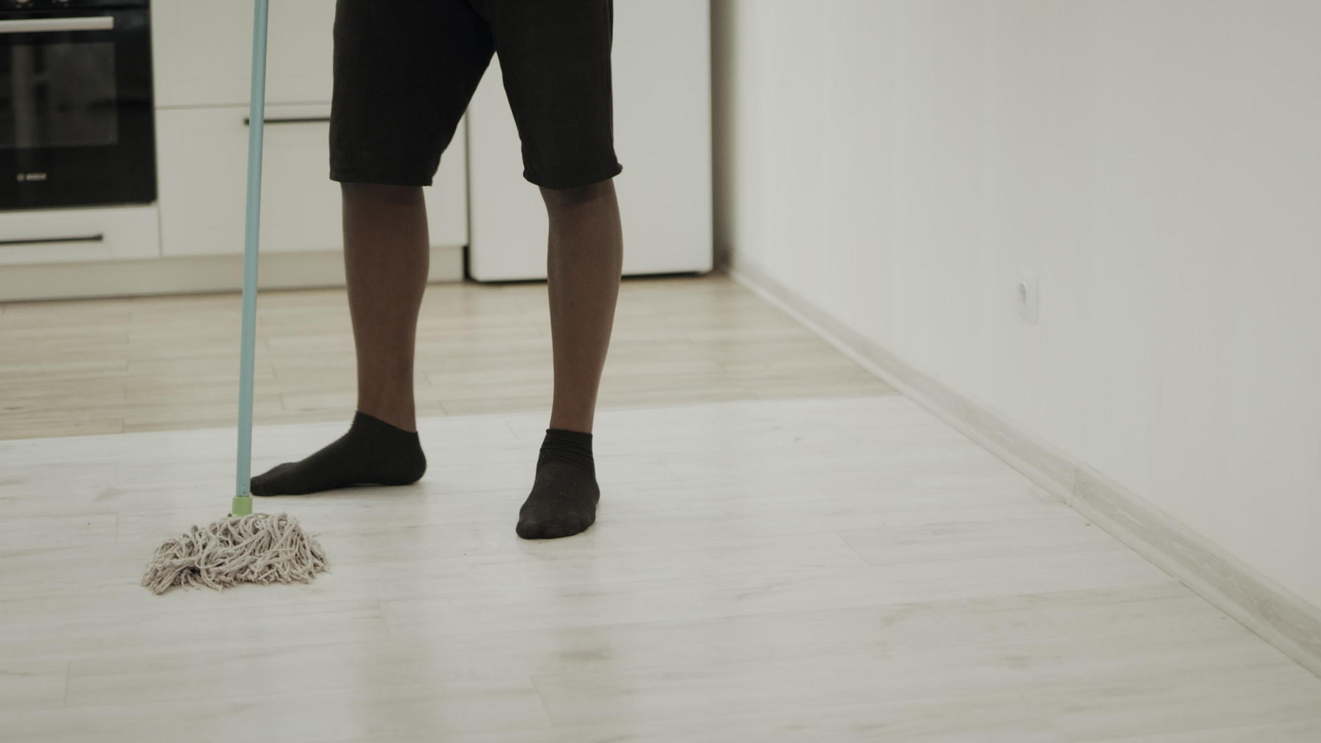 厨房里的黑人用拖把清洁地板视频的预览图