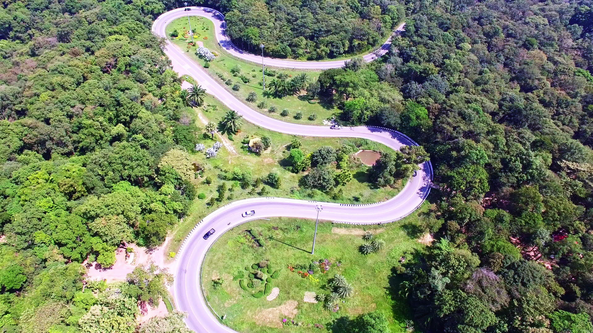 汽车穿过山上的绿林蜿蜒道路视频的预览图