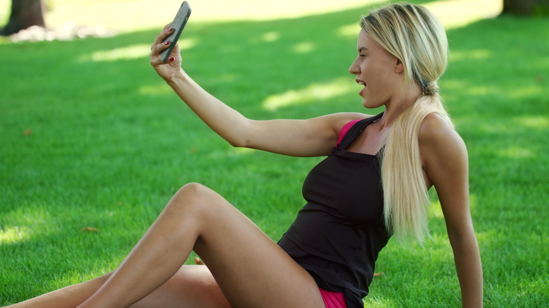 在夏季公园手机上拍摄的金发女人视频的预览图