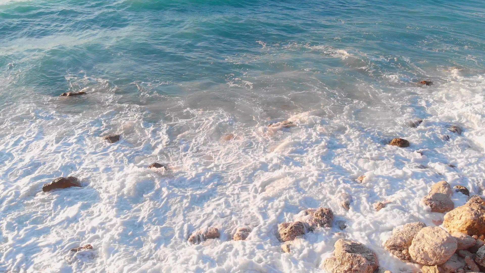 日落时冲进岩石海岸的海浪视频的预览图