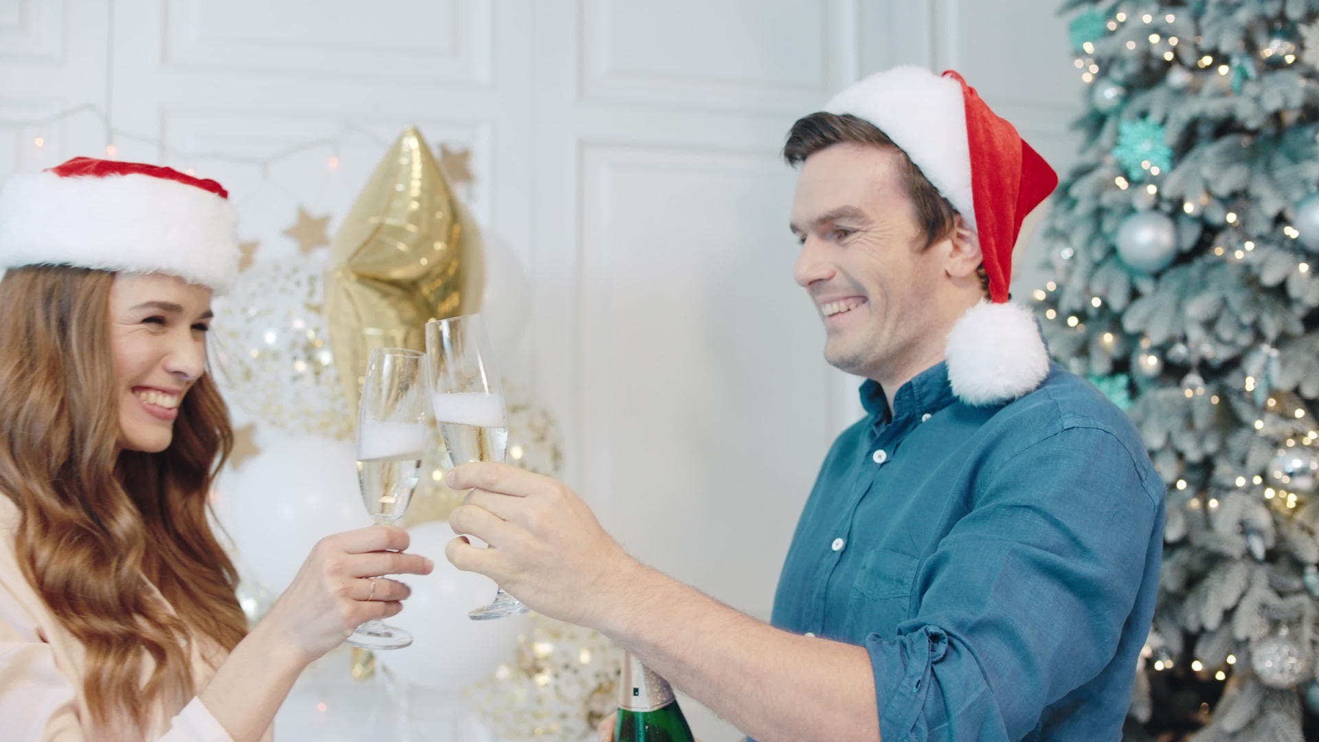 一对幸福的夫妇在圣诞树附近喝香槟视频的预览图