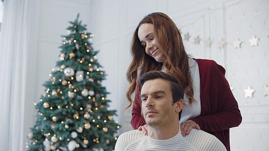 妻子按摩丈夫在圣诞节装饰房间视频的预览图