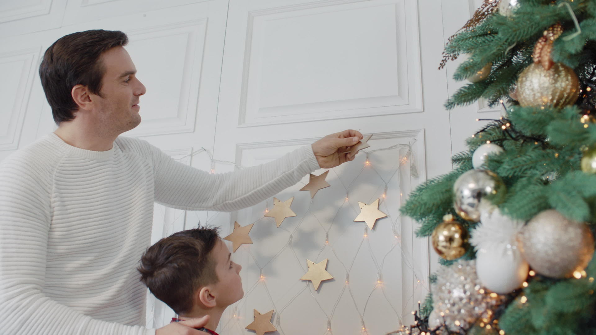 快乐的父亲和儿子把金星放在墙上豪华房间视频的预览图
