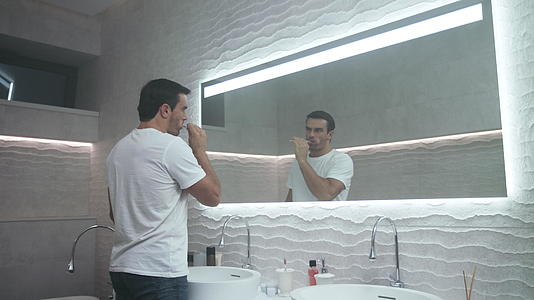 快乐的男人在浴室刷牙视频的预览图