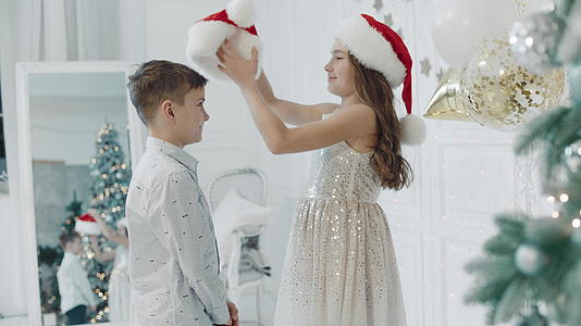 在圣诞树霞里 幸福的姐姐和哥哥拥抱在一起视频的预览图