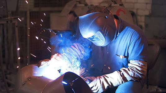 金属加工厂的工业人员将钢焊接到保护面罩中视频的预览图