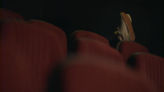 男人睡在空荡荡的电影院视频的预览图