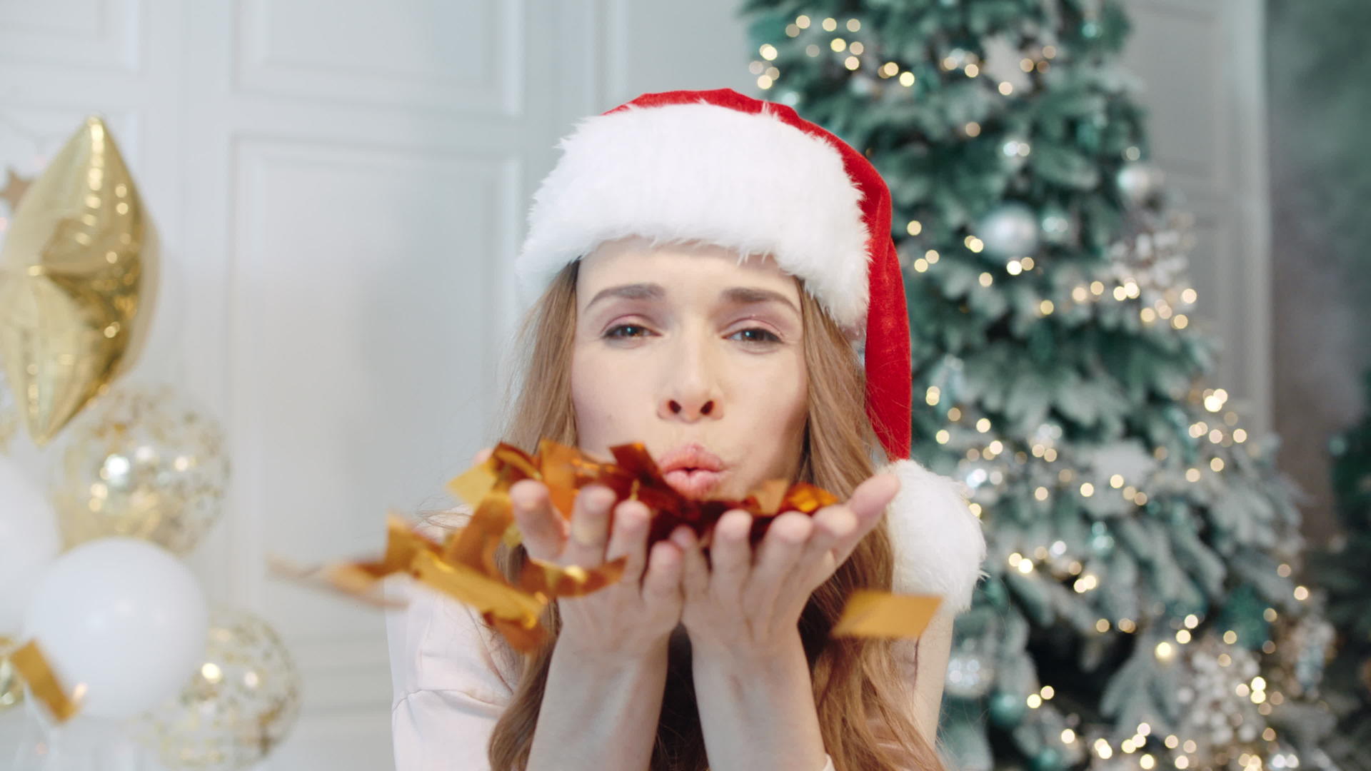 女人在圣诞节吹彩条视频的预览图