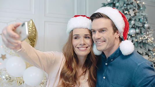 微笑的情侣在圣诞树附近自拍视频的预览图