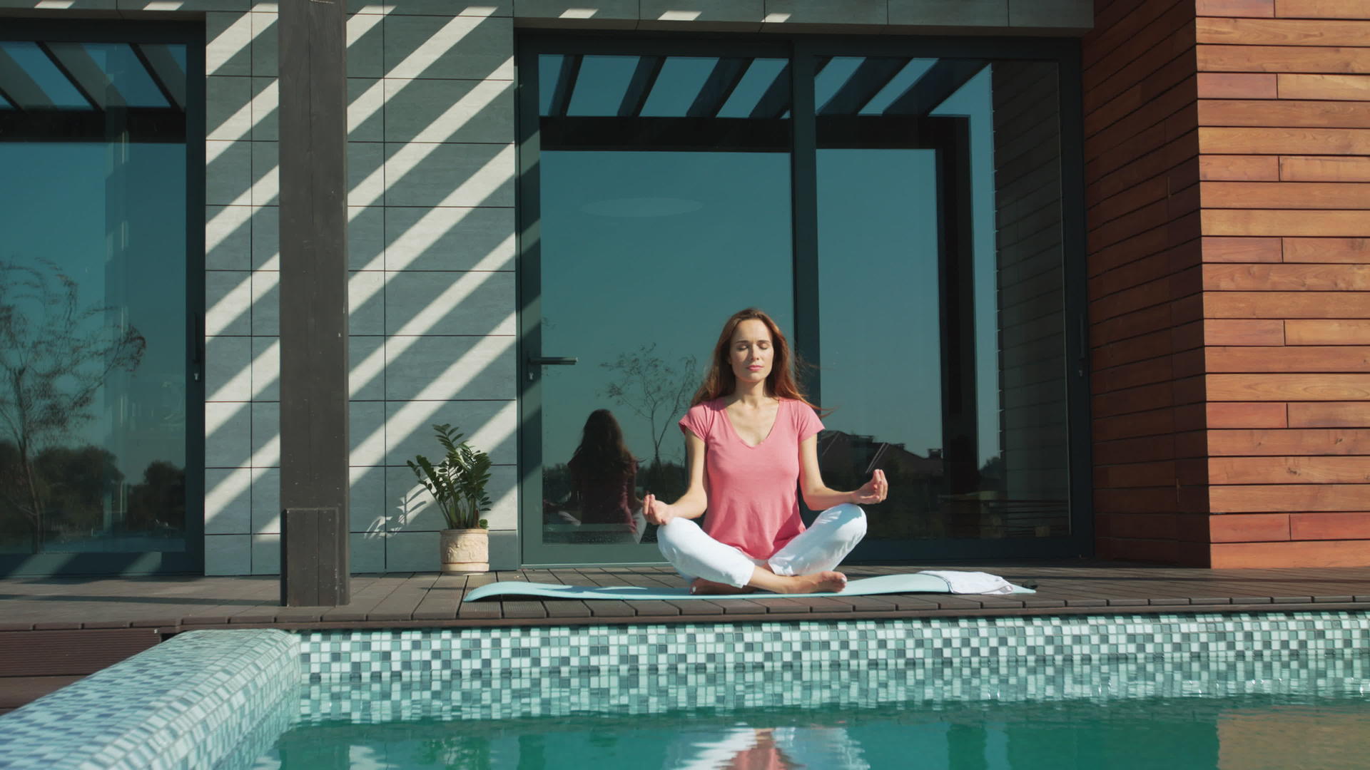 放松的女人在游泳池附近冥想视频的预览图