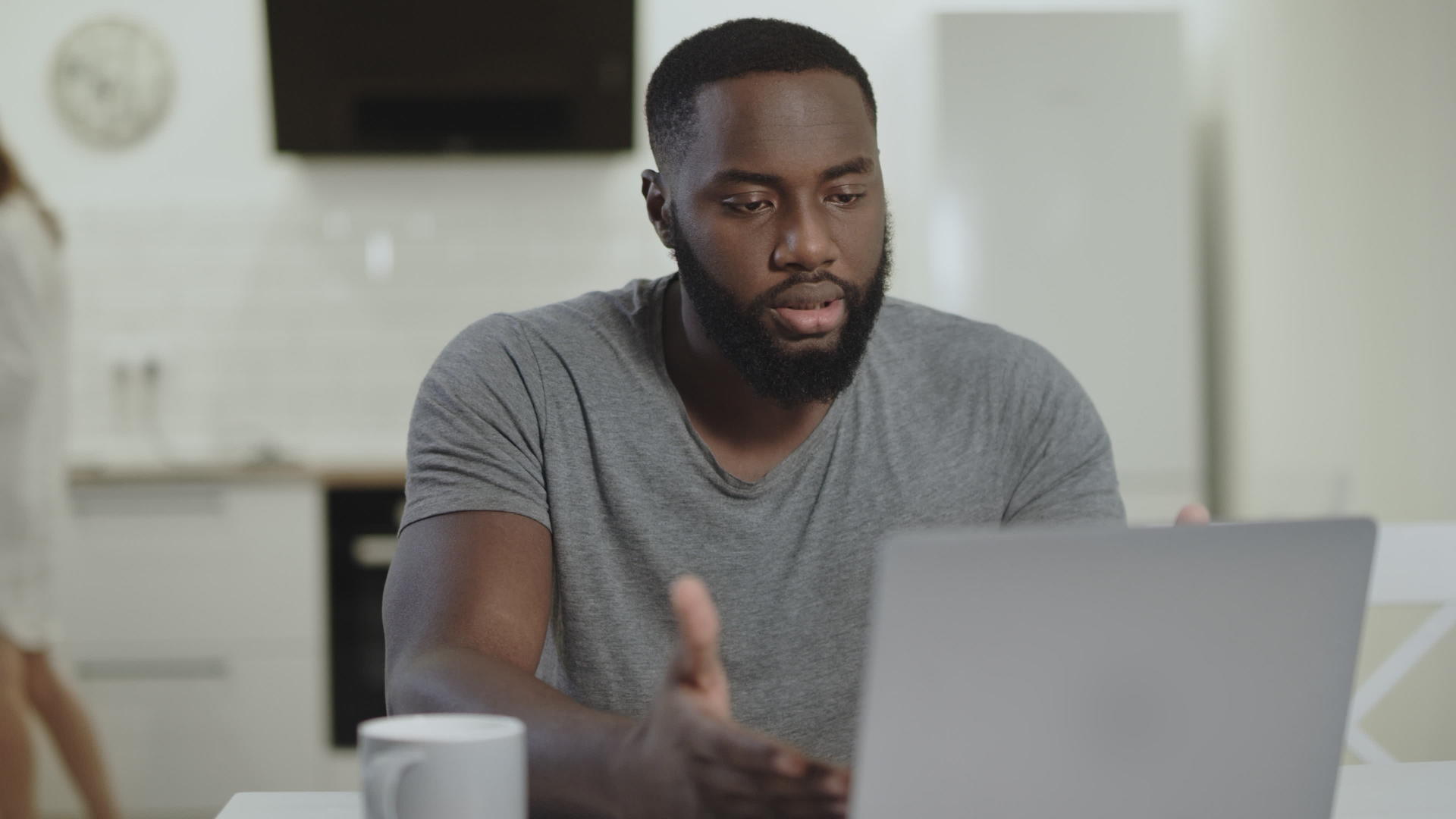 悲伤的黑人男人在露天厨房做笔记本电脑视频的预览图