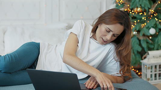 商业女性在豪华卧室看电脑屏幕视频的预览图