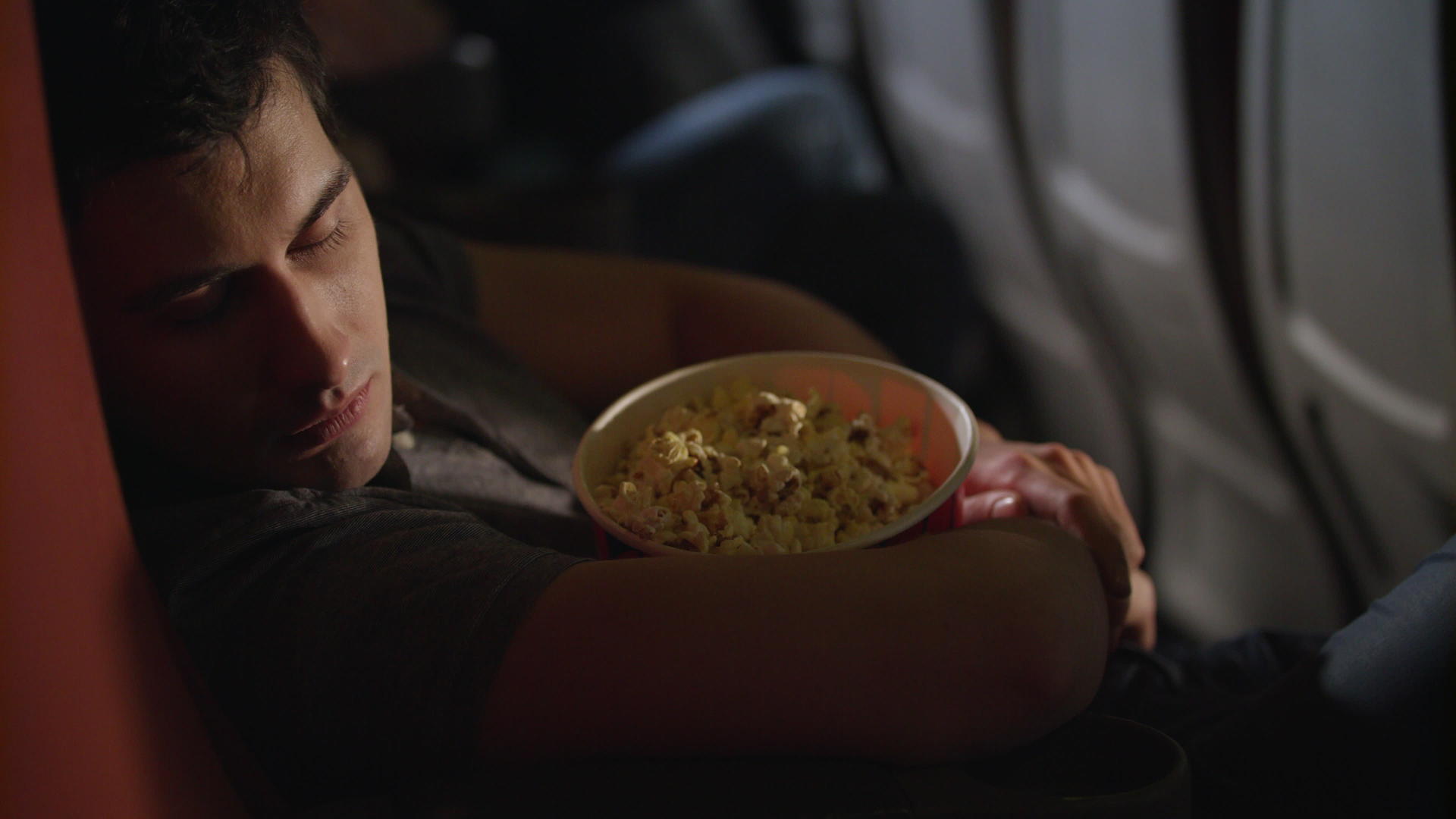 睡着的男人在电影院吃爆米花盒视频的预览图