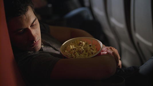 睡着的男人在电影院吃爆米花盒视频的预览图
