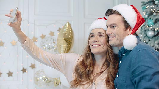 一对夫妇在圣诞树旁边自拍视频的预览图
