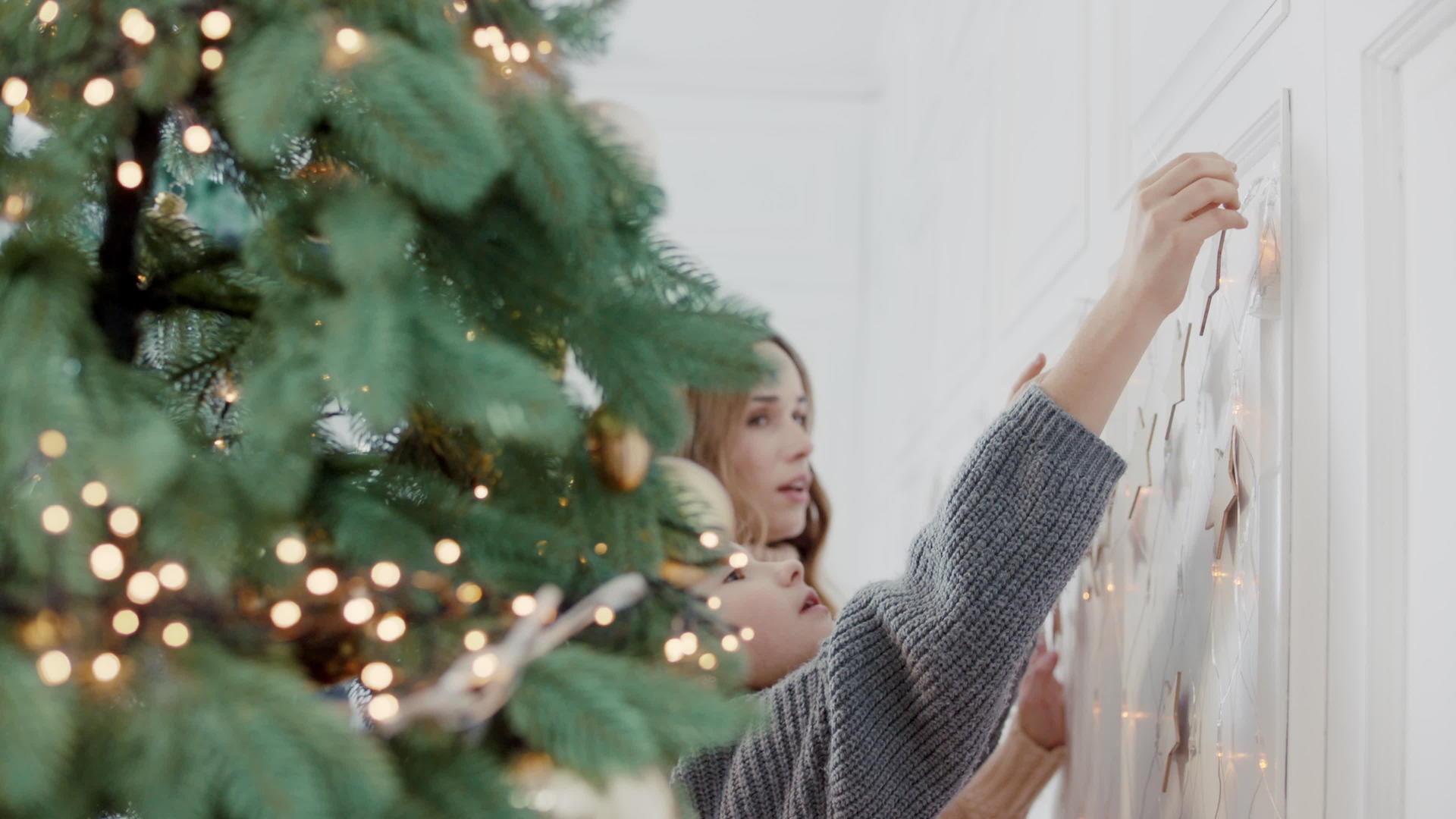 微笑的人拥抱女孩在客厅的圣诞树旁边视频的预览图
