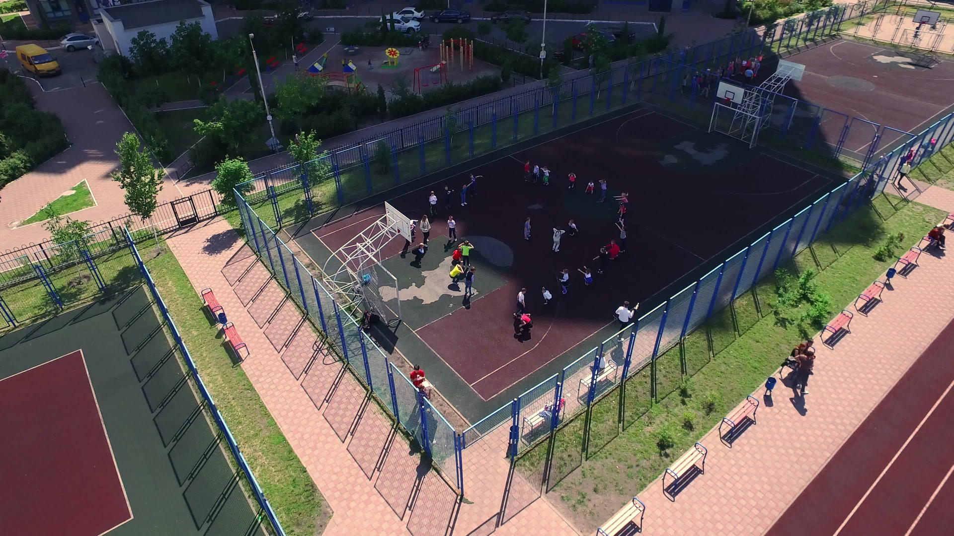 在学校院子里的篮球场上观看孩子们的体育课视频的预览图