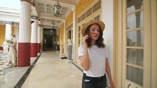 夏季旅游期间旅游女性在古建筑的柱形走廊上行视频的预览图