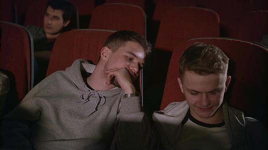 两个在电影院看智能手机的家伙视频的预览图