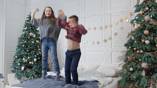 圣诞节 两个微笑的青少年在豪华的房子里跳床视频的预览图