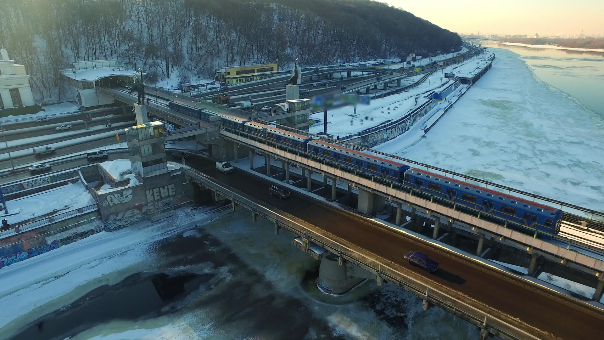 在城市冬季河上乘坐桥梁铁路的地方列车视频的预览图