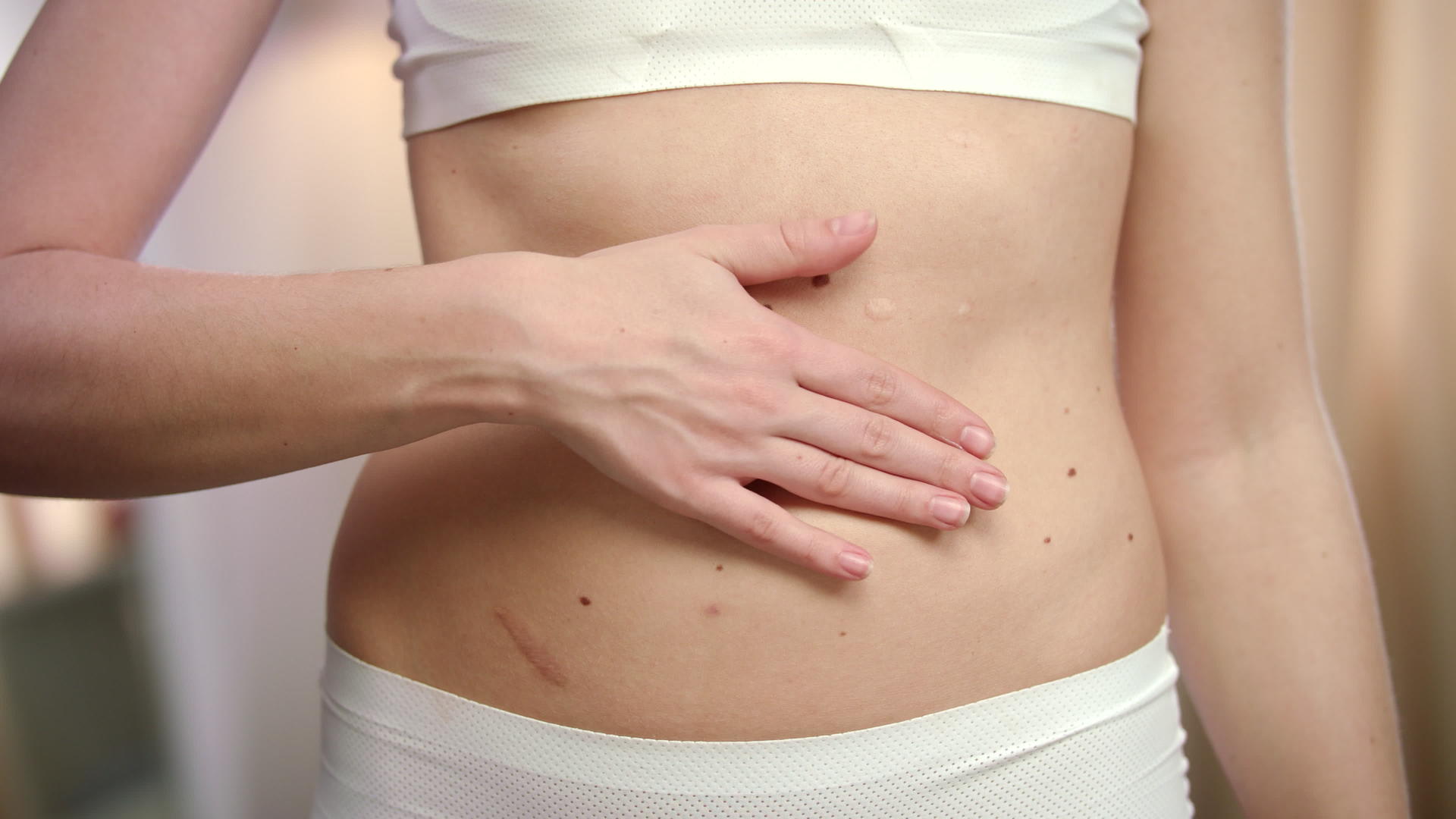 女性用手在腹部涂抹身体乳液视频的预览图