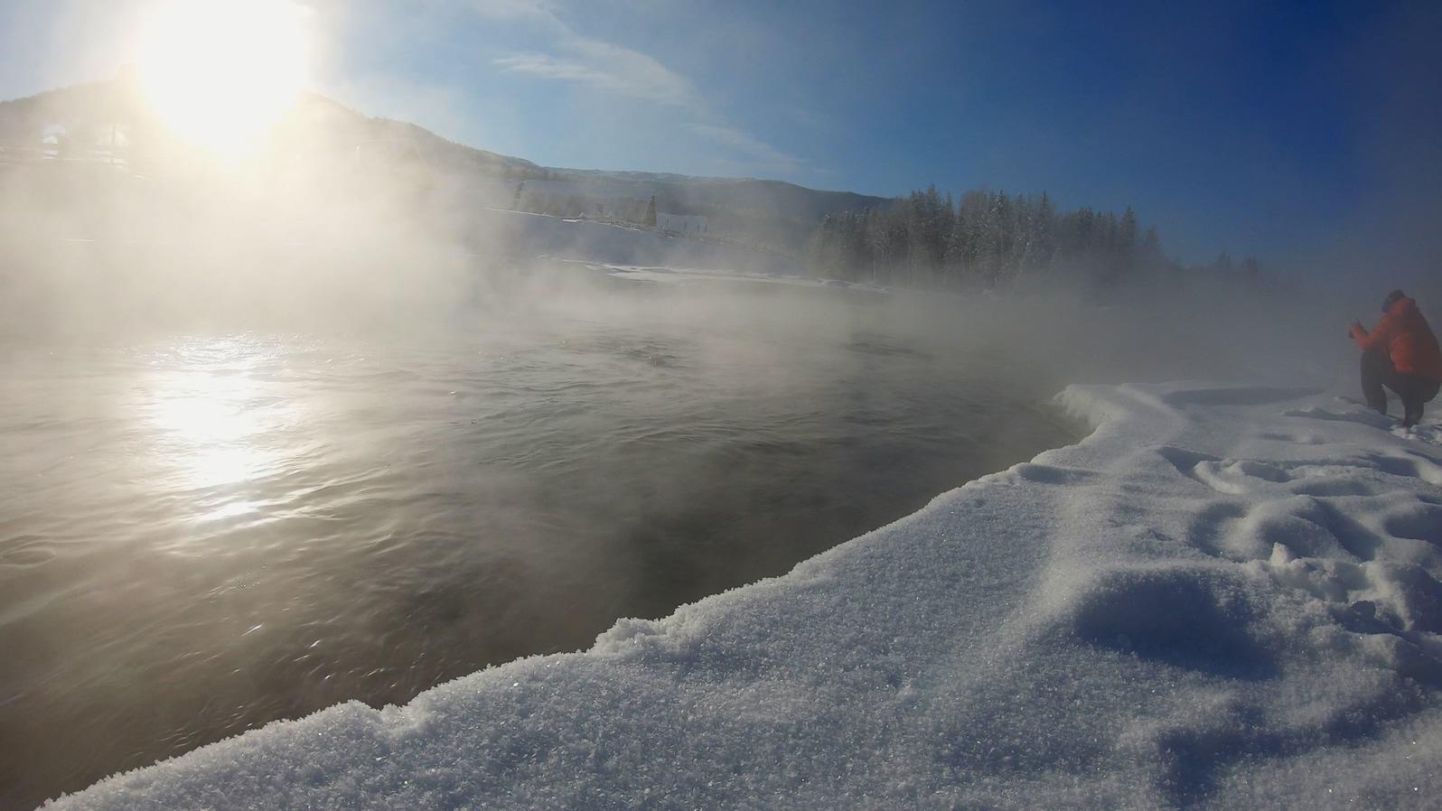 新疆冬季旅游风光禾木河水流淌晨雾白雪蓝天视频的预览图