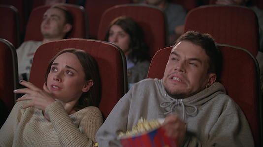在电影院看恐怖电影的年轻夫妇视频的预览图