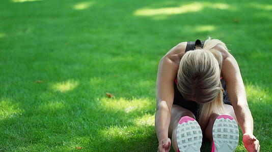 运动员妇女在夏季公园健身训练前做伸展运动视频的预览图