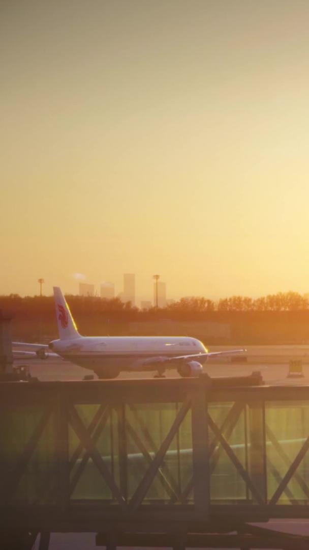 黄昏时分机场廊桥下飞机推着行李箱的乘客视频的预览图
