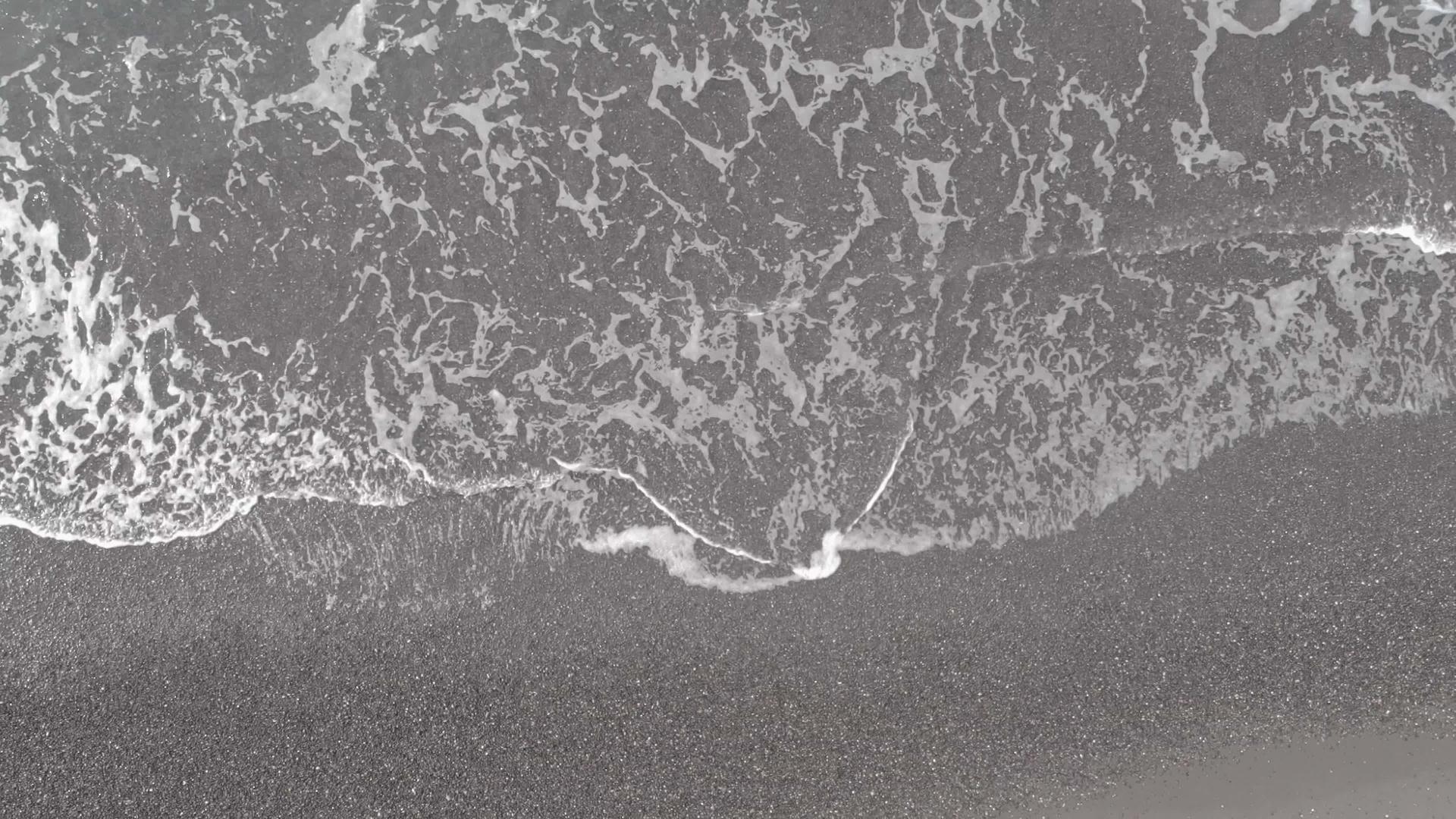 观察黑色沙滩和桑托里尼海浪的空气视频的预览图