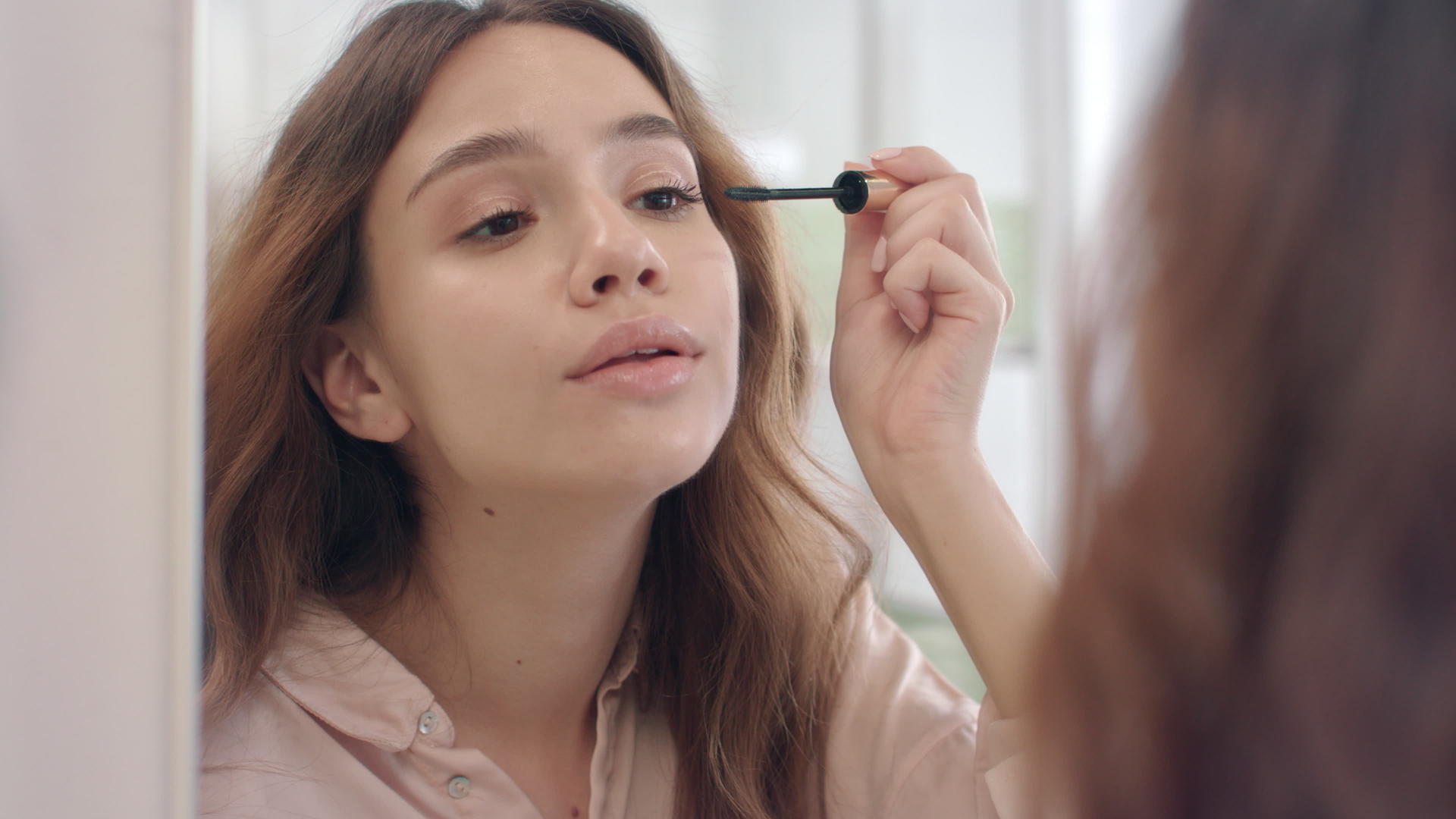 女子在浴室化妆镜前刷睫毛膏视频的预览图