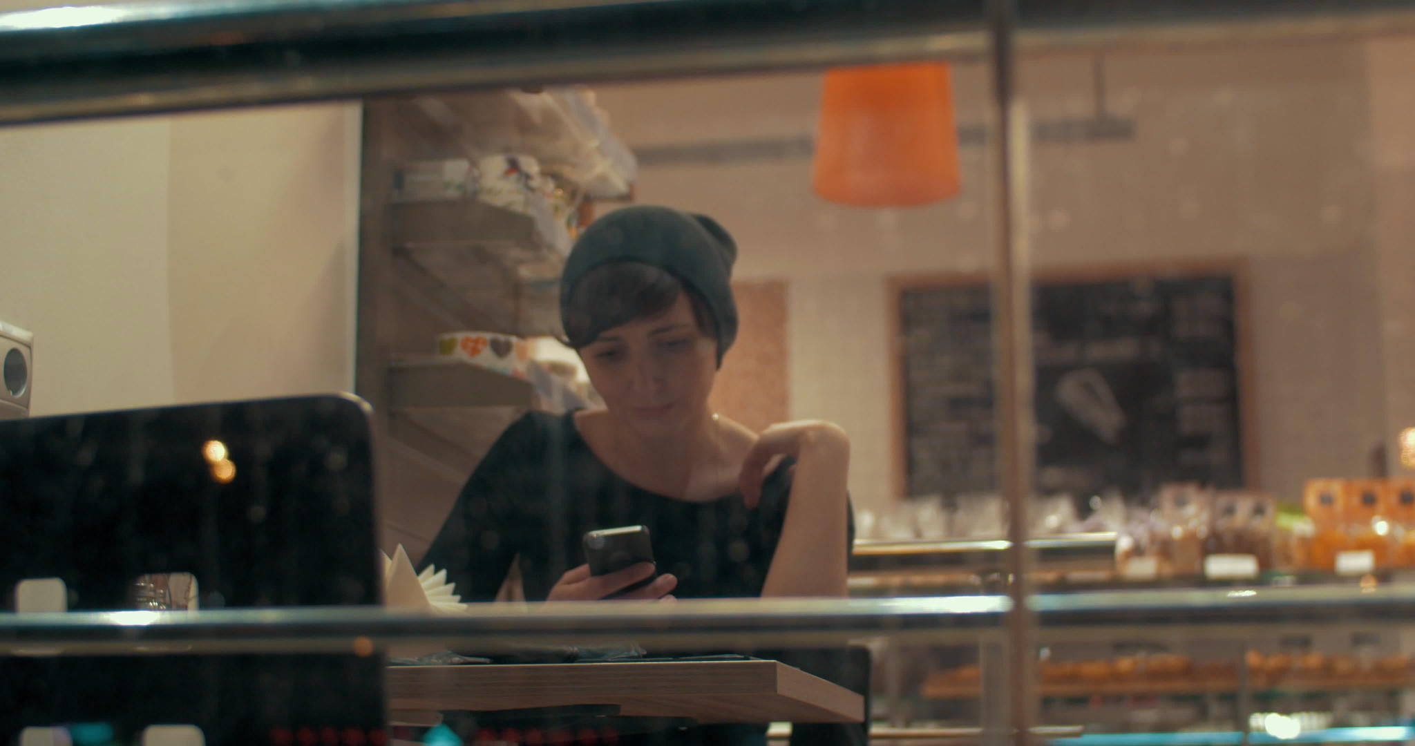 咖啡馆里的年轻女孩用快乐的外表在手机上打字视频的预览图