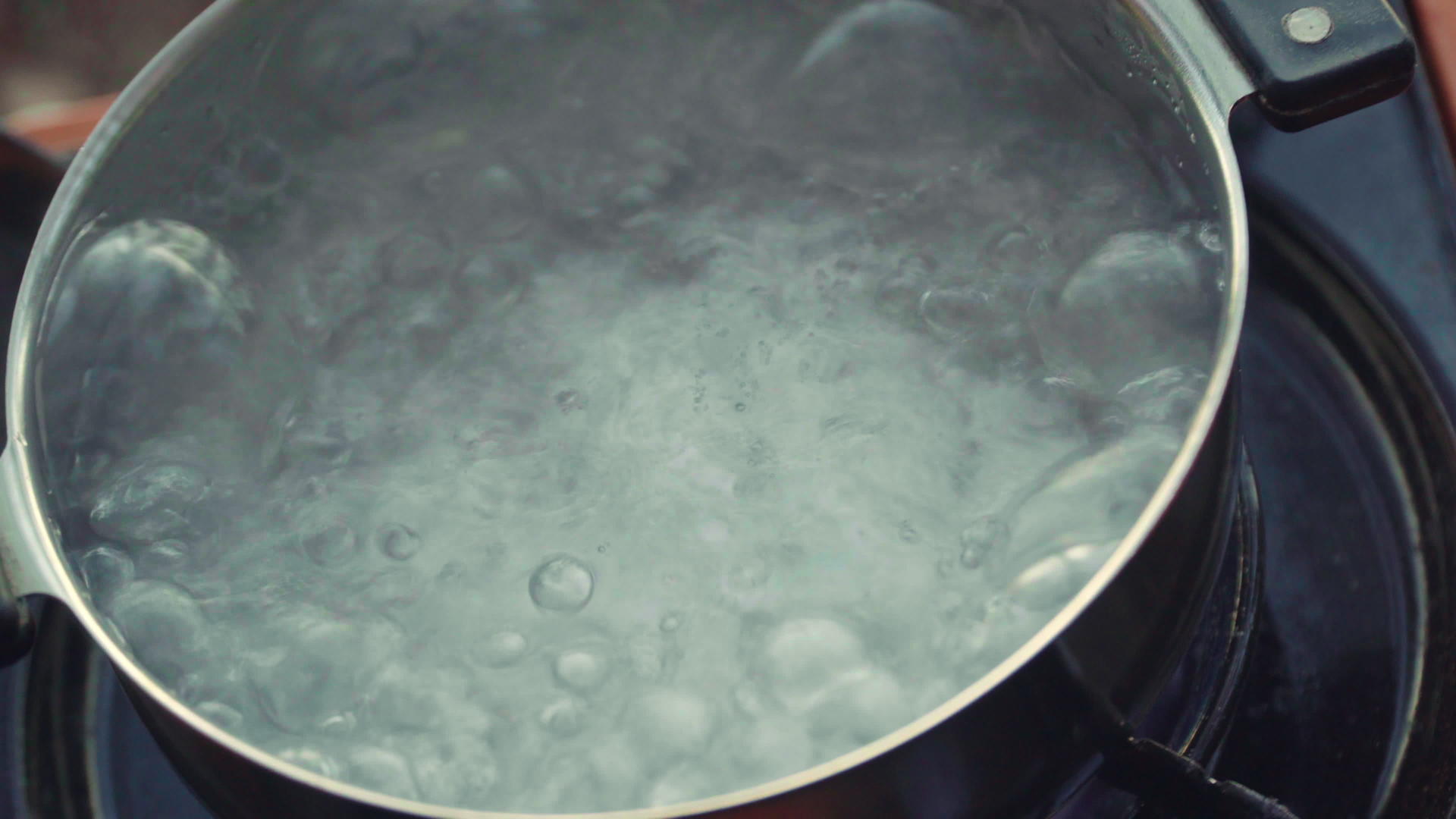 在徒步旅行期间在煤气炉上煮茶时用沸水煮茶视频的预览图