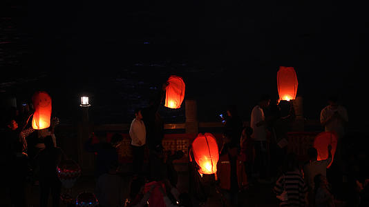 晚上在湖北襄阳汉江边燃放孔明灯祈福人群4k素材视频的预览图