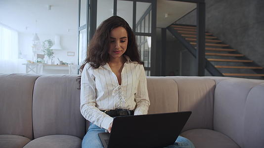 女商人在家庭办公室用慢动作打笔记本电脑视频的预览图