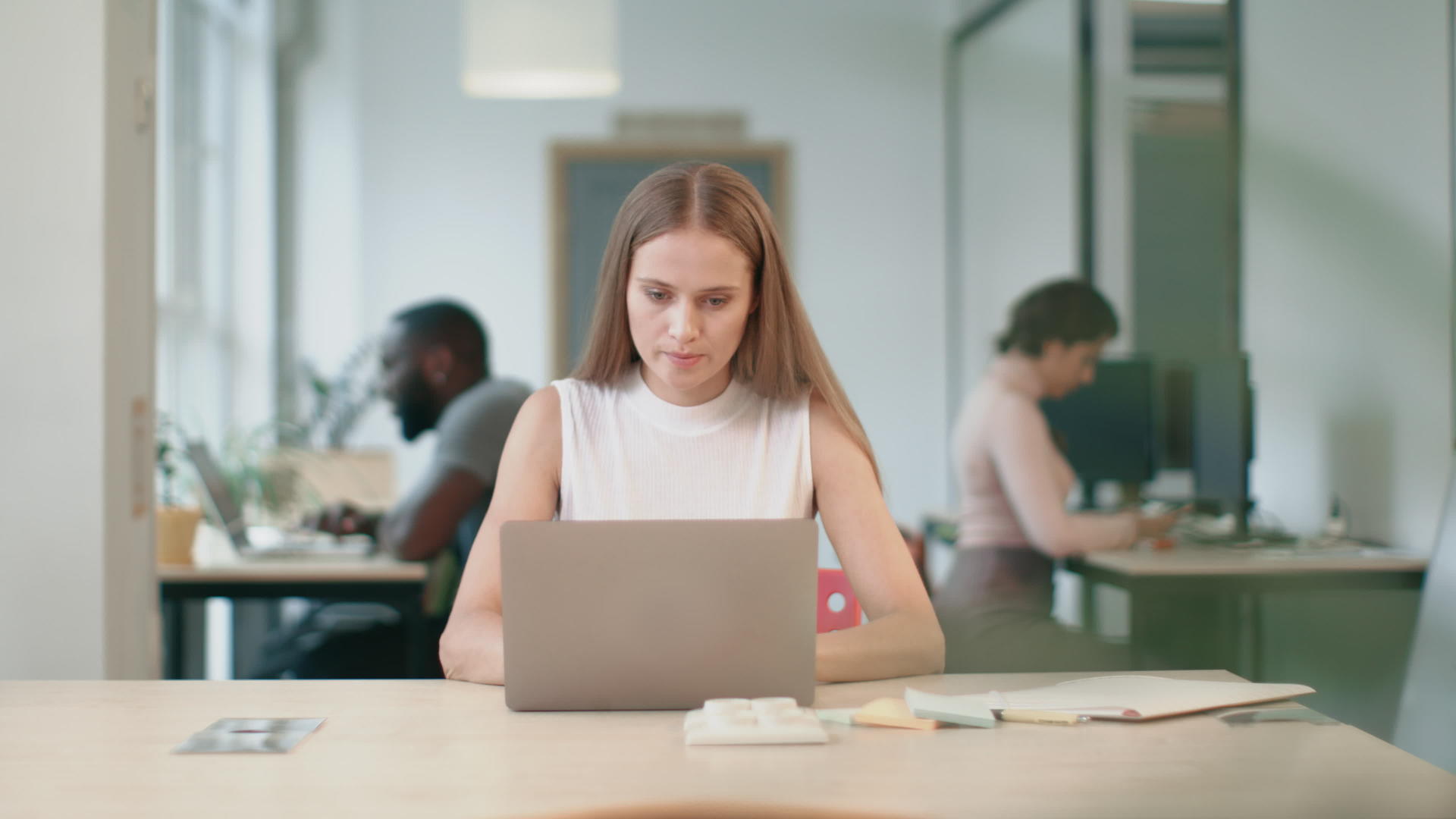 商业女性在同事工作时在笔记本电脑上工作视频的预览图