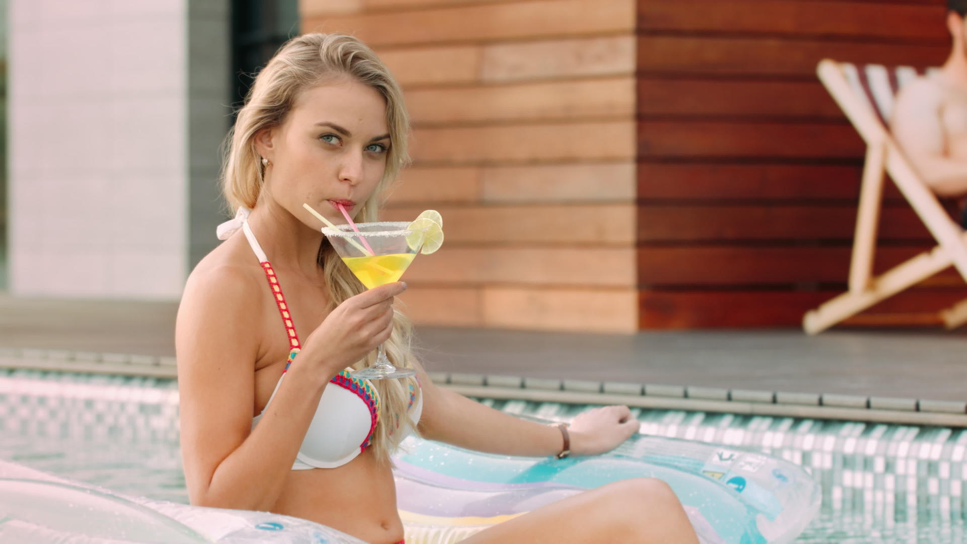 迷人的女人在游泳池里喝鸡尾酒视频的预览图