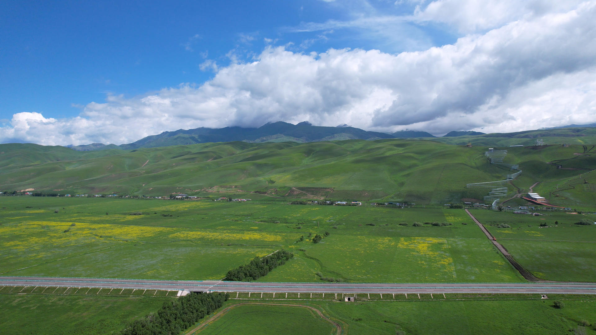 新疆航拍一望无际的高山草原和高速公路4k素材视频的预览图