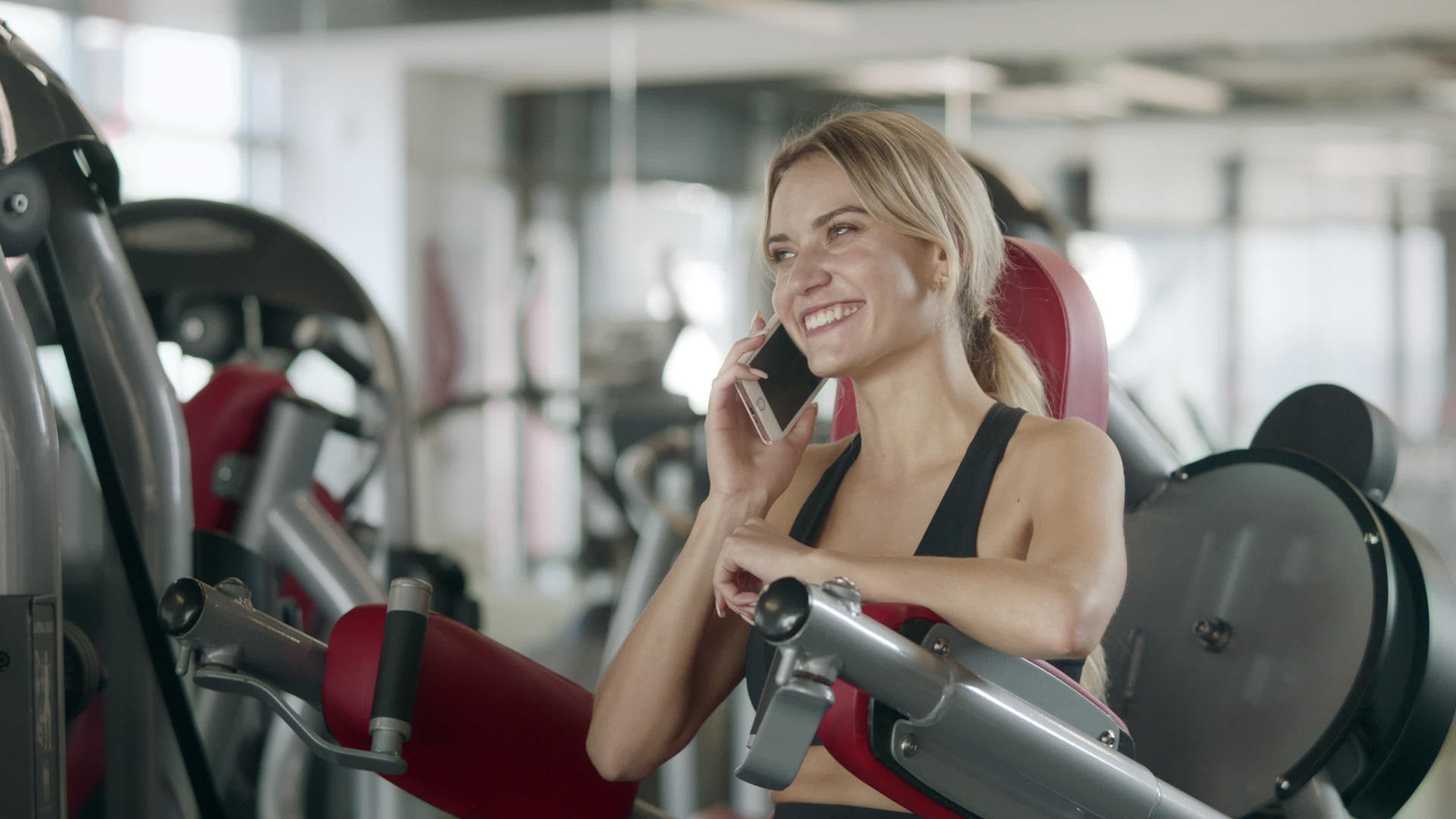 在健身房训练机上谈论快乐的女人视频的预览图