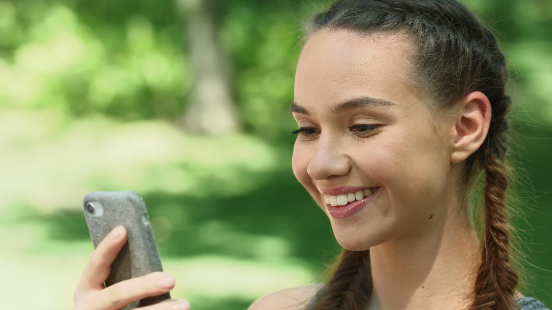 在夏月公园早上跑步时使用手机的快乐女人视频的预览图