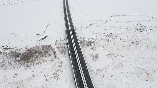4K航拍新疆冬季雪原高速公路旅游风光视频的预览图