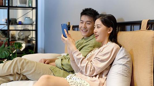 4k年轻夫妻男女朋友情侣在床上看手机看视频视频的预览图