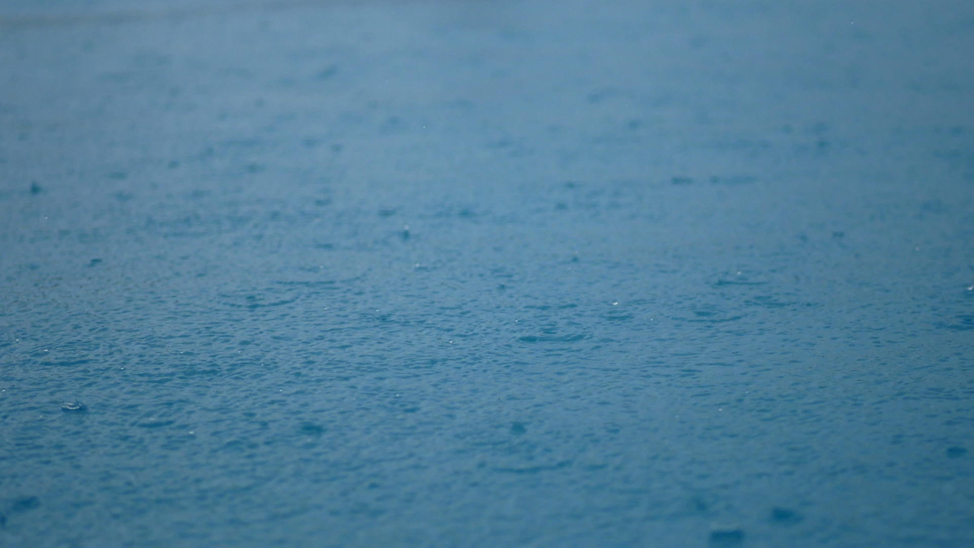 清澈的蓝色水面上的雨滴特写视频的预览图