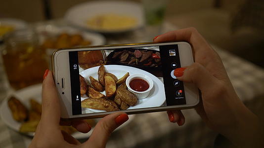 拿着智能手机为社交网络拍摄食物照片视频的预览图