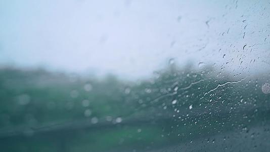 梅雨天气汽车玻璃上划过的水珠光斑视频的预览图