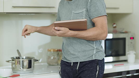 男人用手和石板在家里的厨房里做健康的食物视频的预览图