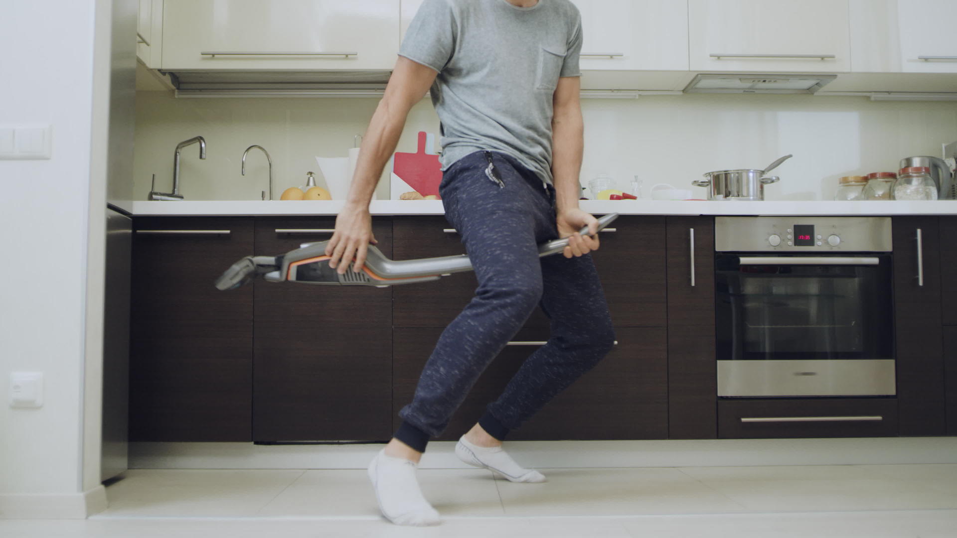 缝合男人的腿和厨房的吸尘器清洁工一起洗地板视频的预览图